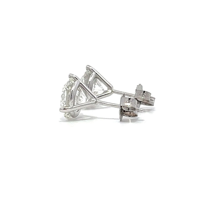 White gold stud earrings with round diamonds on a white background.