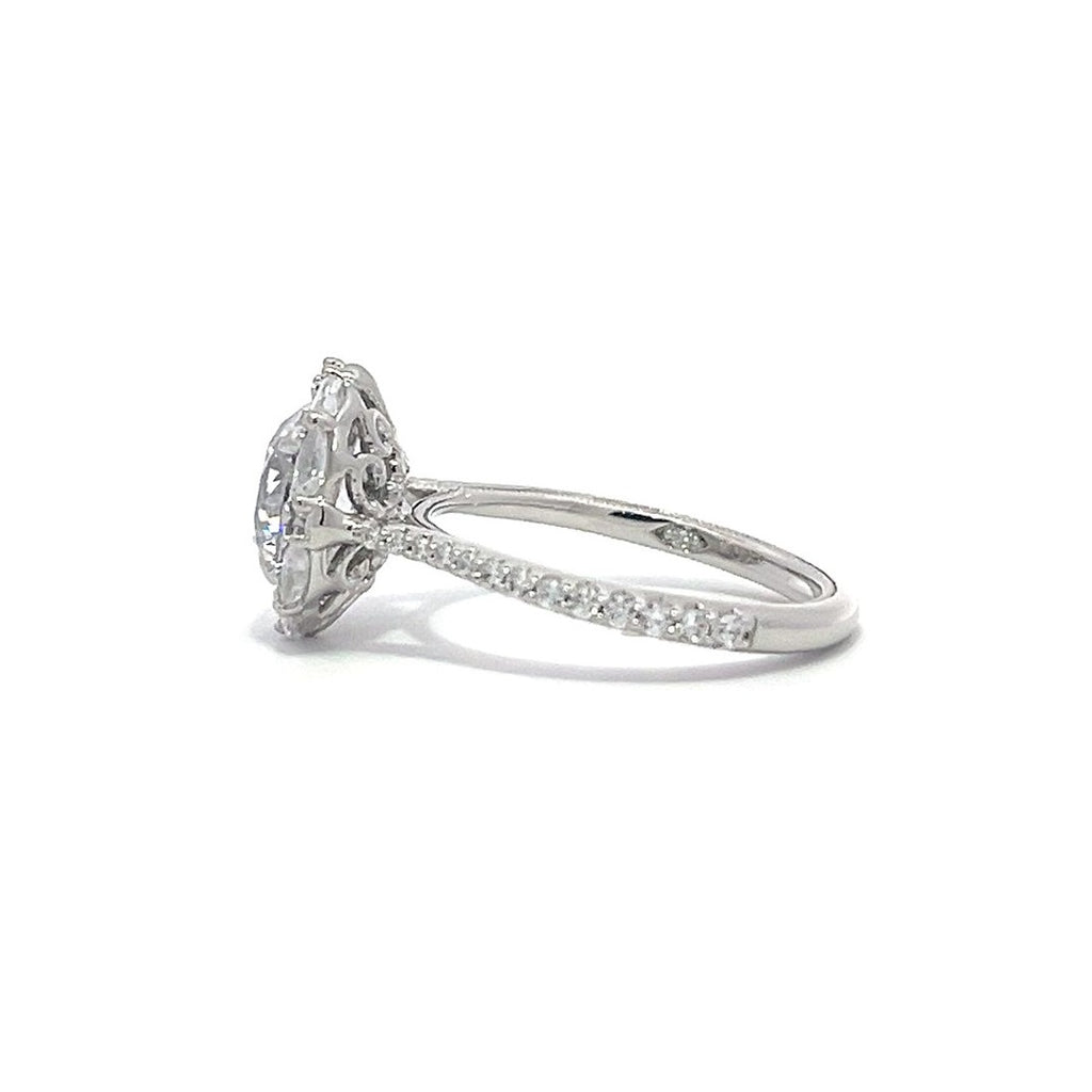 Silver engagement ring with a diamond halo setting and a diamond band on a white background