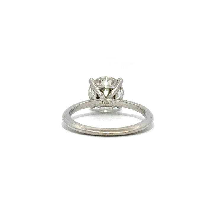 Silver solitaire engagement ring with a round-cut diamond center stone on a white background.