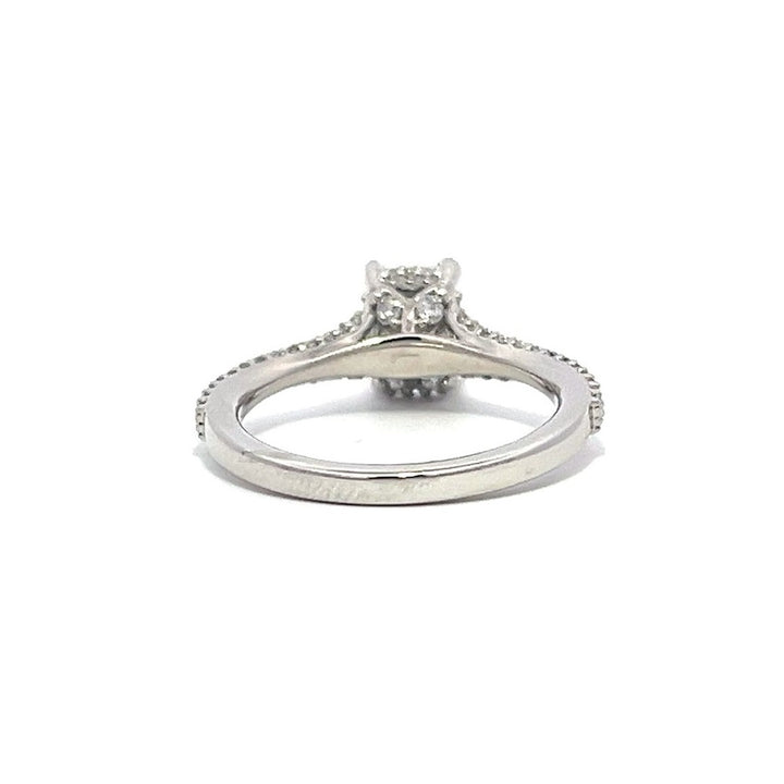 White gold emerald-cut diamond engagement ring with a diamond band on a white background.