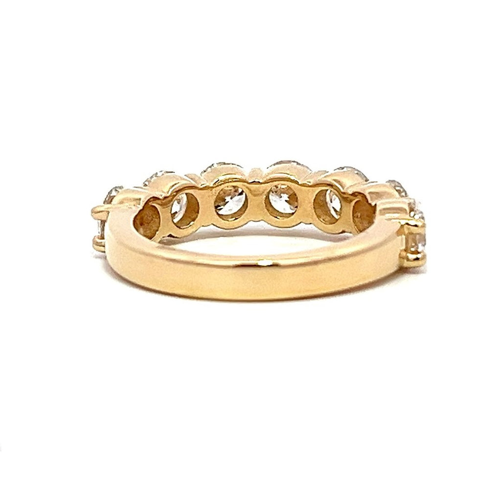 Yellow gold eternity band with round diamonds on a white background