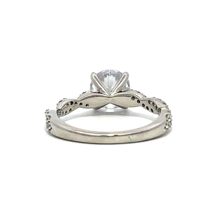 White gold diamond engagement ring with a twisted band on a white background.