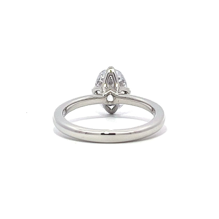 White gold oval diamond solitaire engagement ring on a white background.