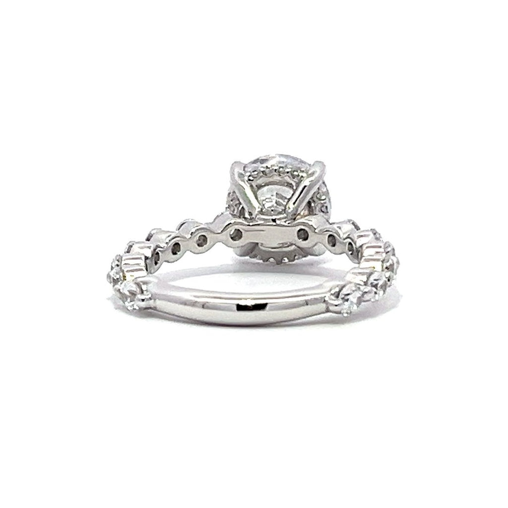 White gold round-shaped diamond engagement ring with a diamond band on a white background.