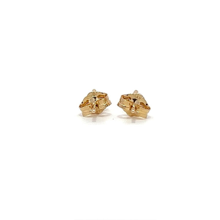 Pair of yellow gold stud earrings with round diamonds on a white background.