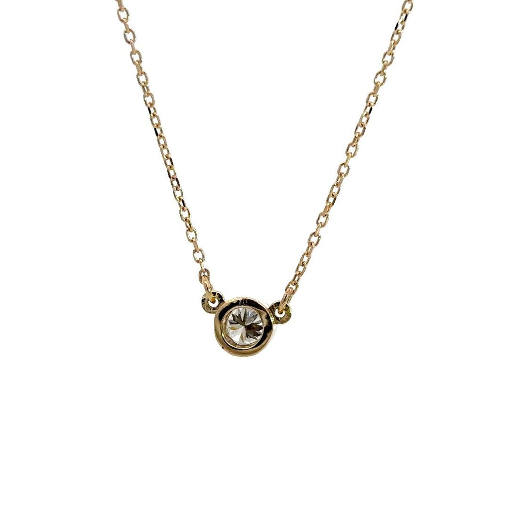 Yellow gold diamond solitaire necklace on a white background