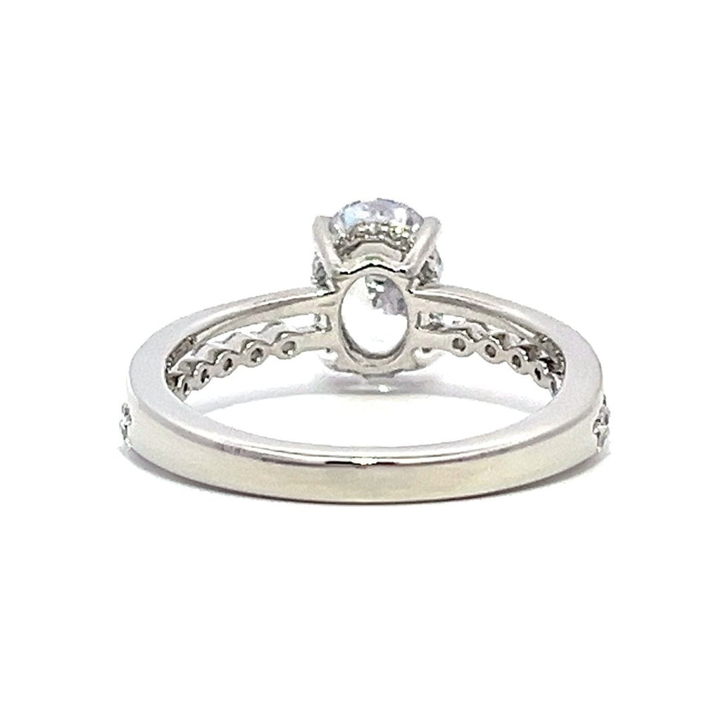 White gold round-shaped diamond engagement ring with a diamond band on a white background.