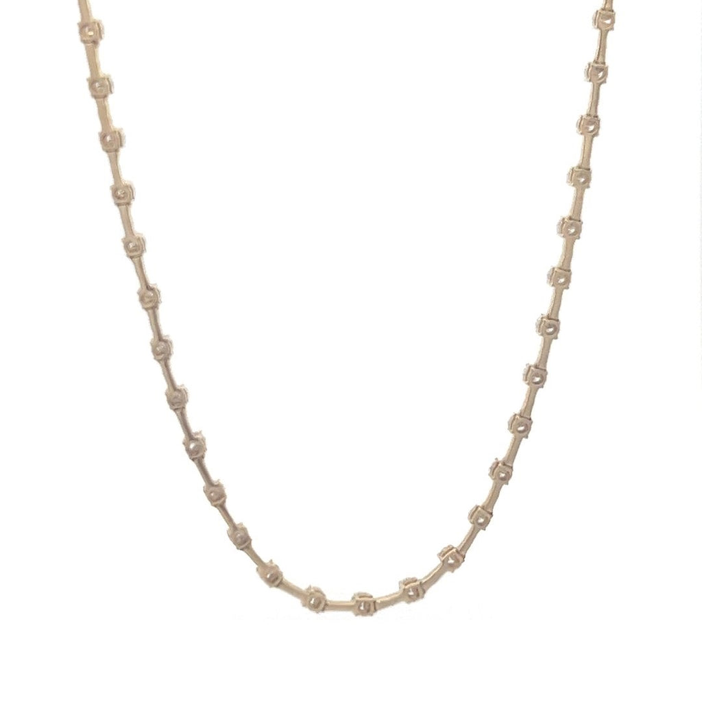 Yellow gold necklace with a row of round diamonds on a white background.