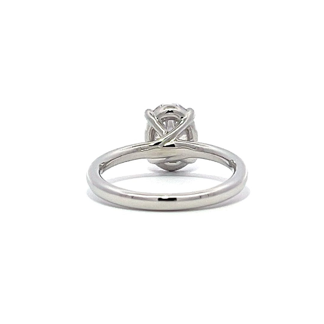 White gold oval diamond solitaire engagement ring on a white background.