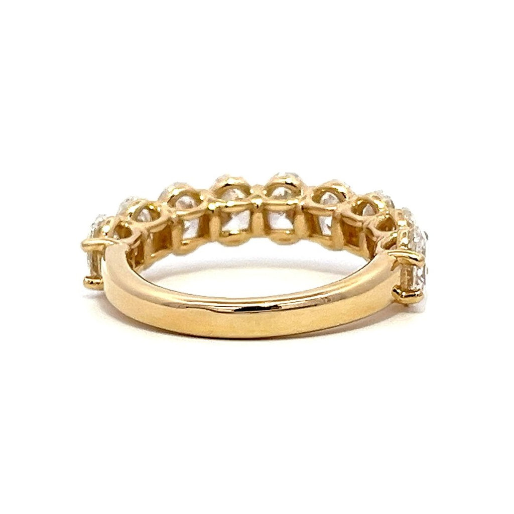 Yellow gold eternity band with oval-shaped diamonds on a white background.