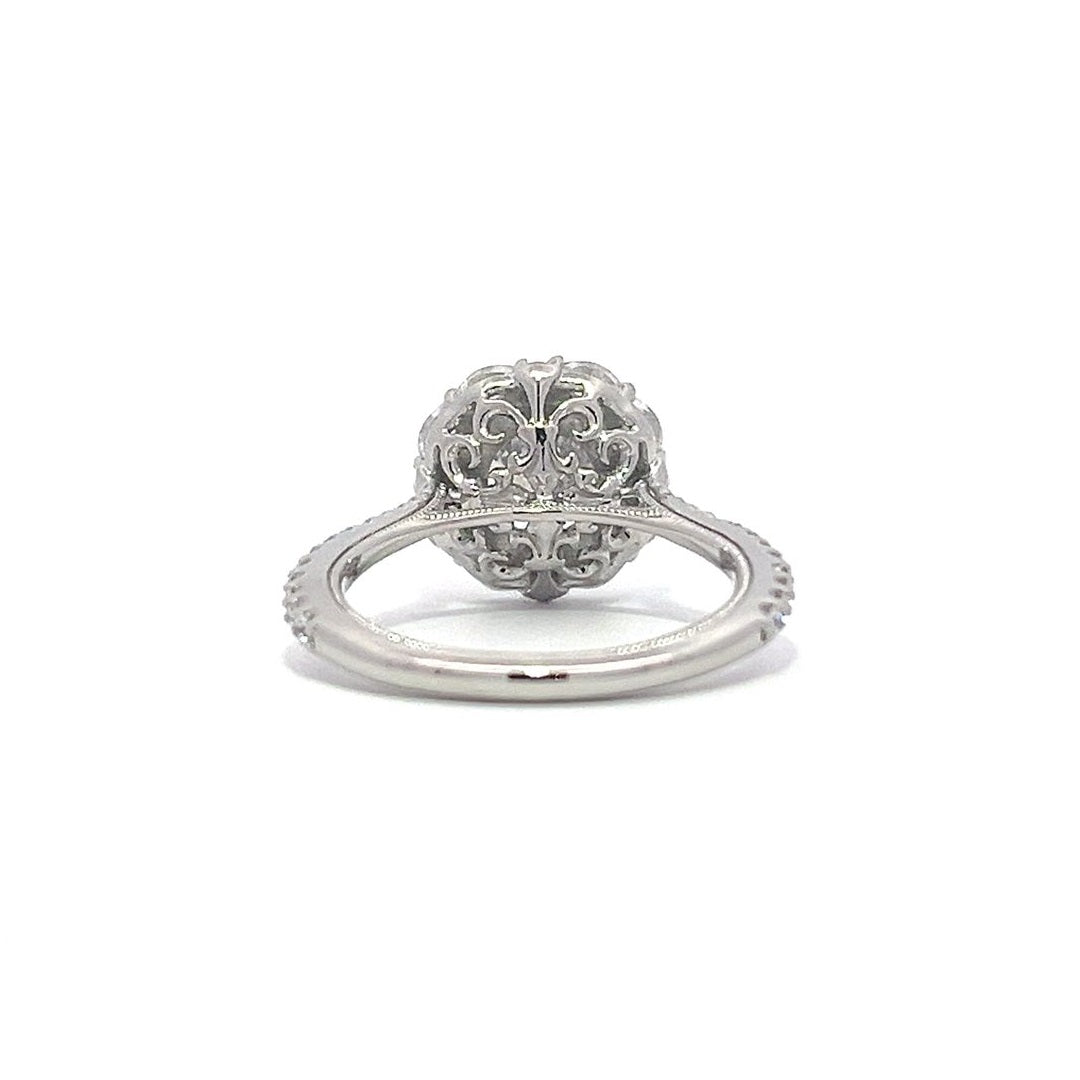 Silver engagement ring with a diamond halo setting and a diamond band on a white background