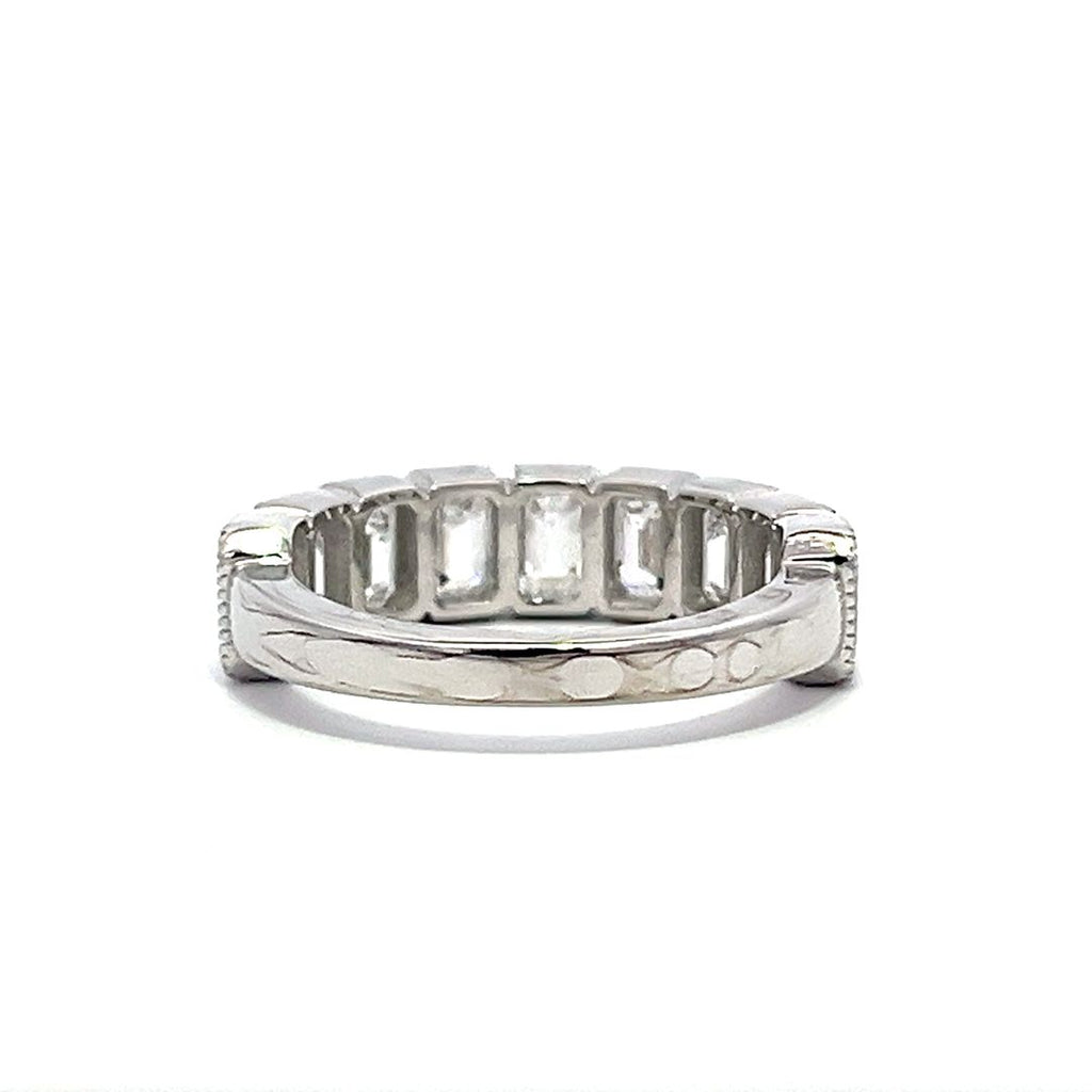 White gold eternity band with bezel-set emerald diamonds on a white background.