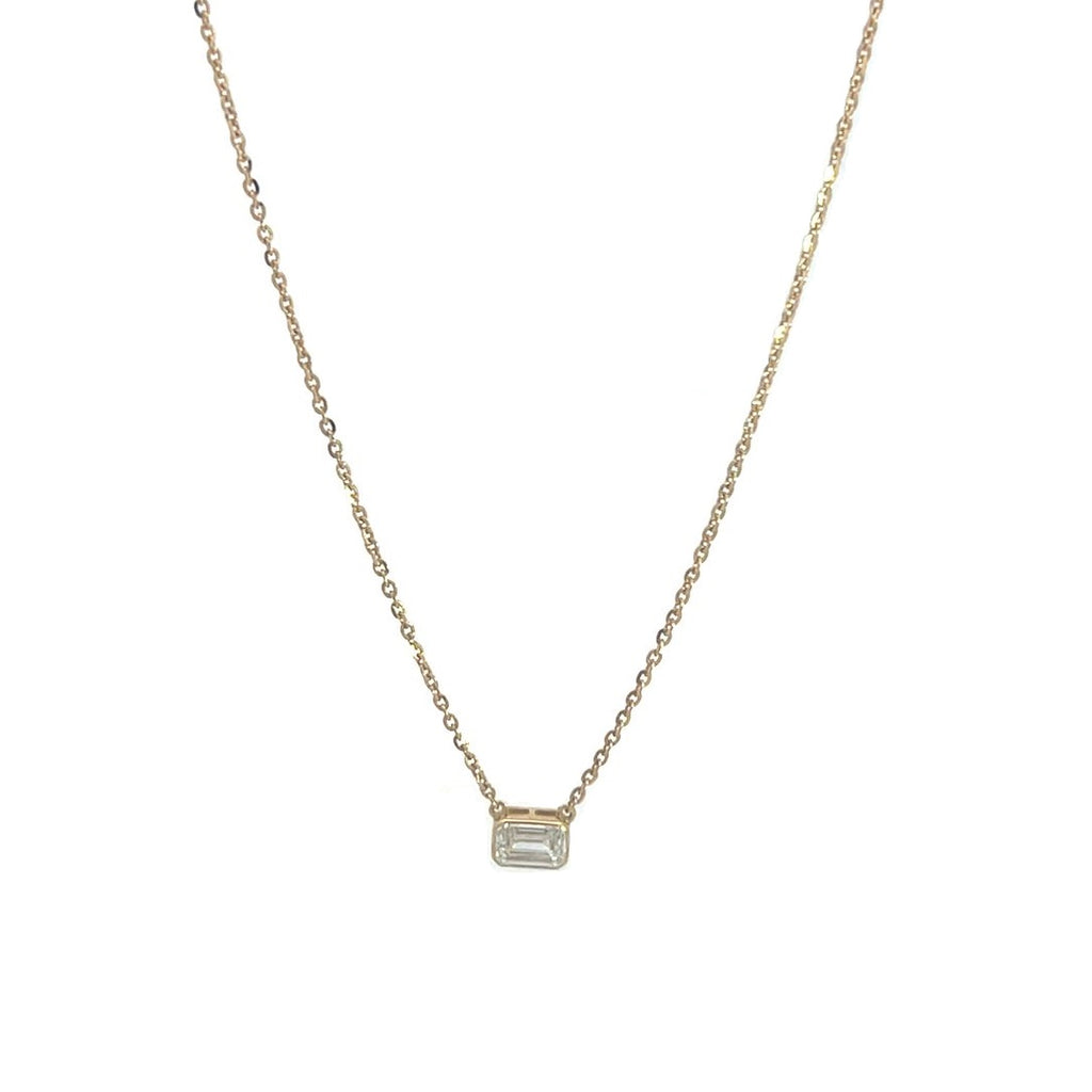 Yellow gold necklace with an emerald-cut diamond pendant on a white background.