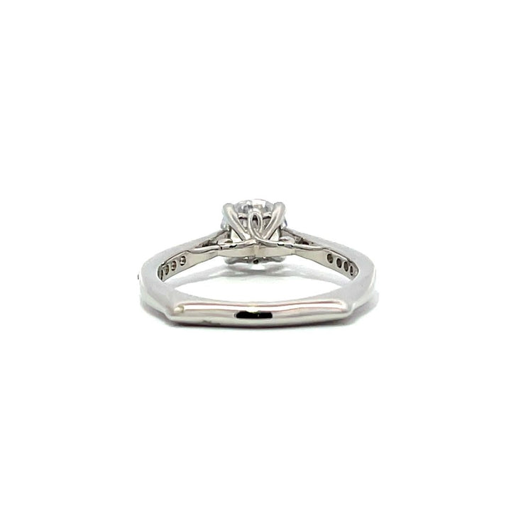 White gold round-shaped diamond engagement ring with a diamond band on a white background.