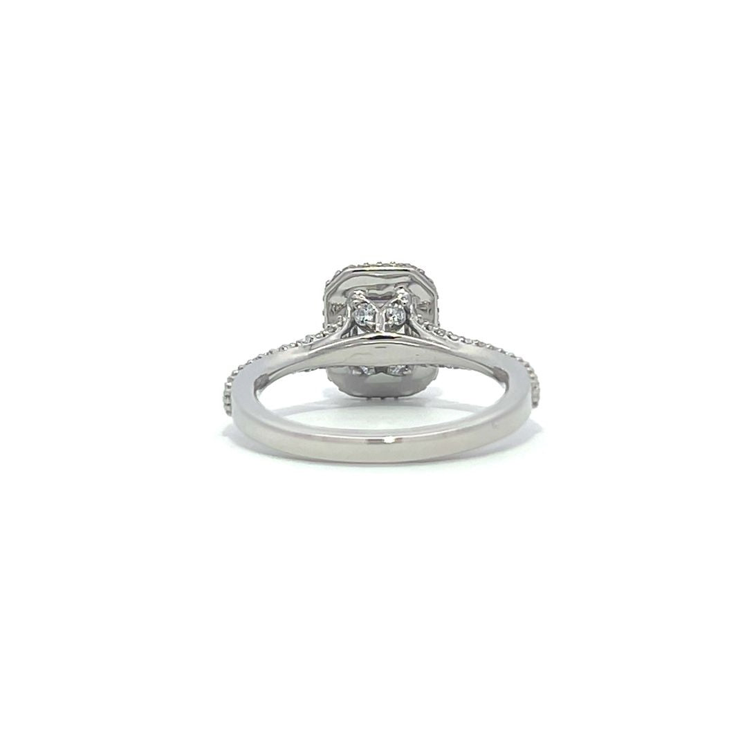 Silver emerald-cut engagement ring with a double halo setting on a white background