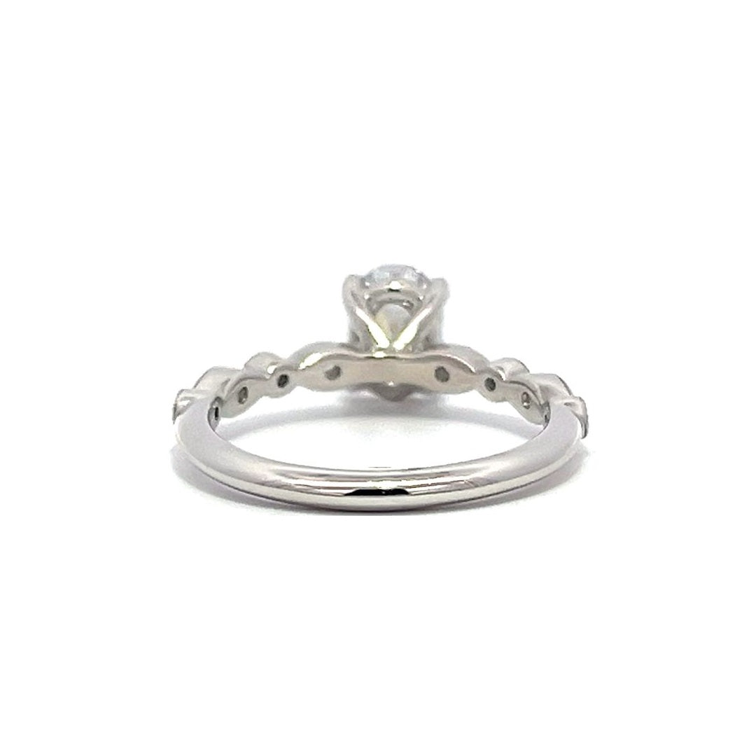 White gold oval diamond engagement ring with a diamond band on a white background.