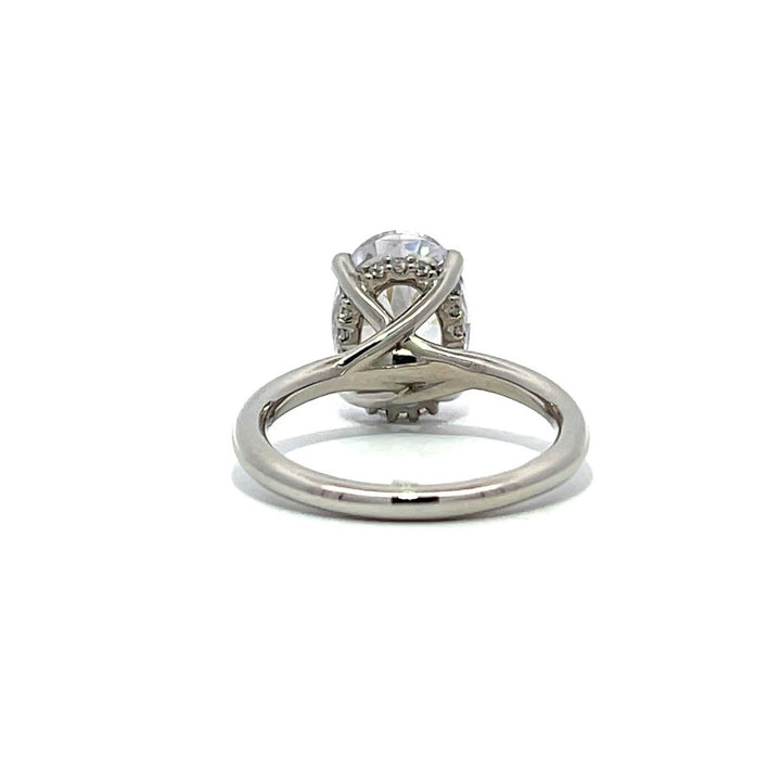 White gold oval diamond solitaire engagement ring on a white background