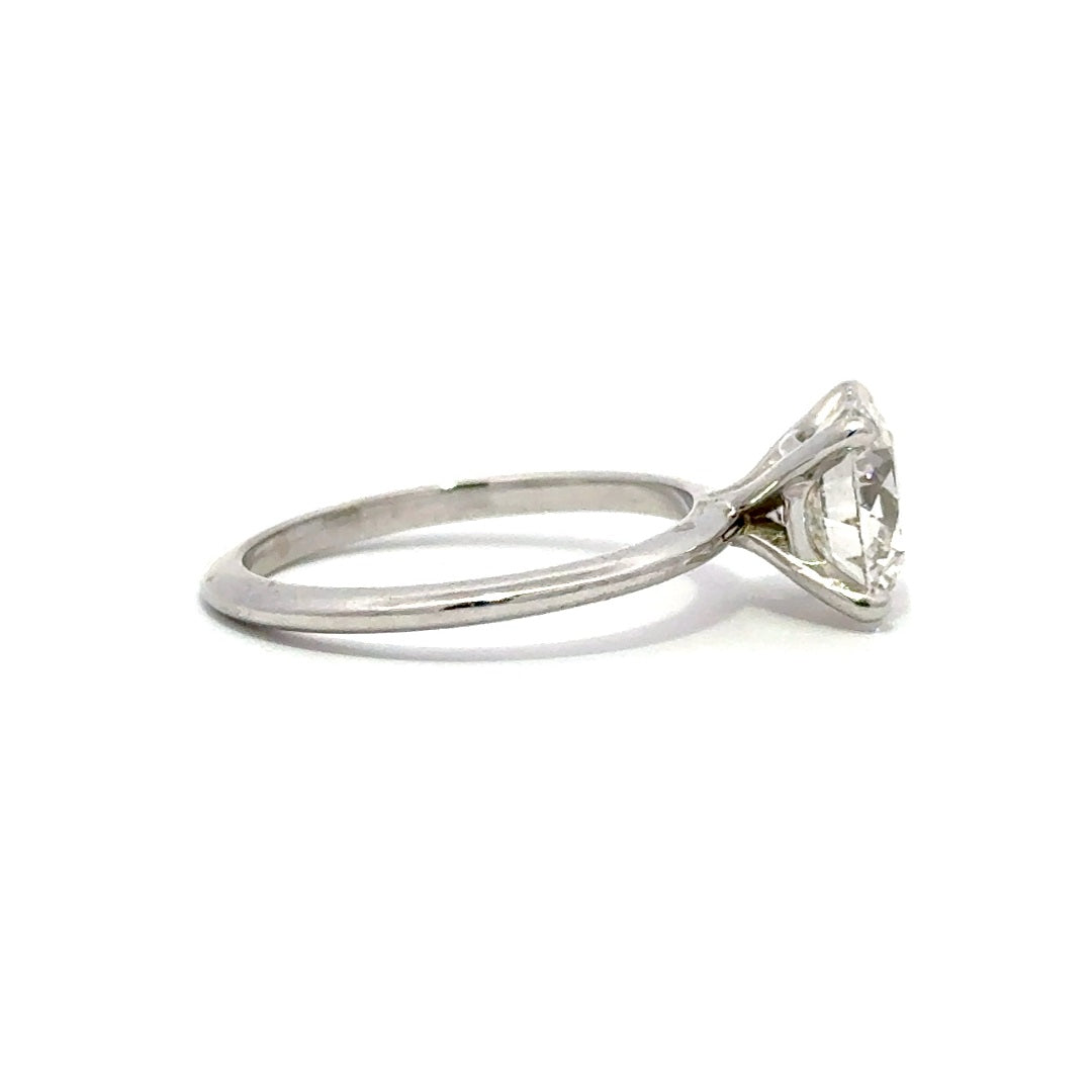 Silver solitaire engagement ring with a round-cut diamond center stone on a white background.