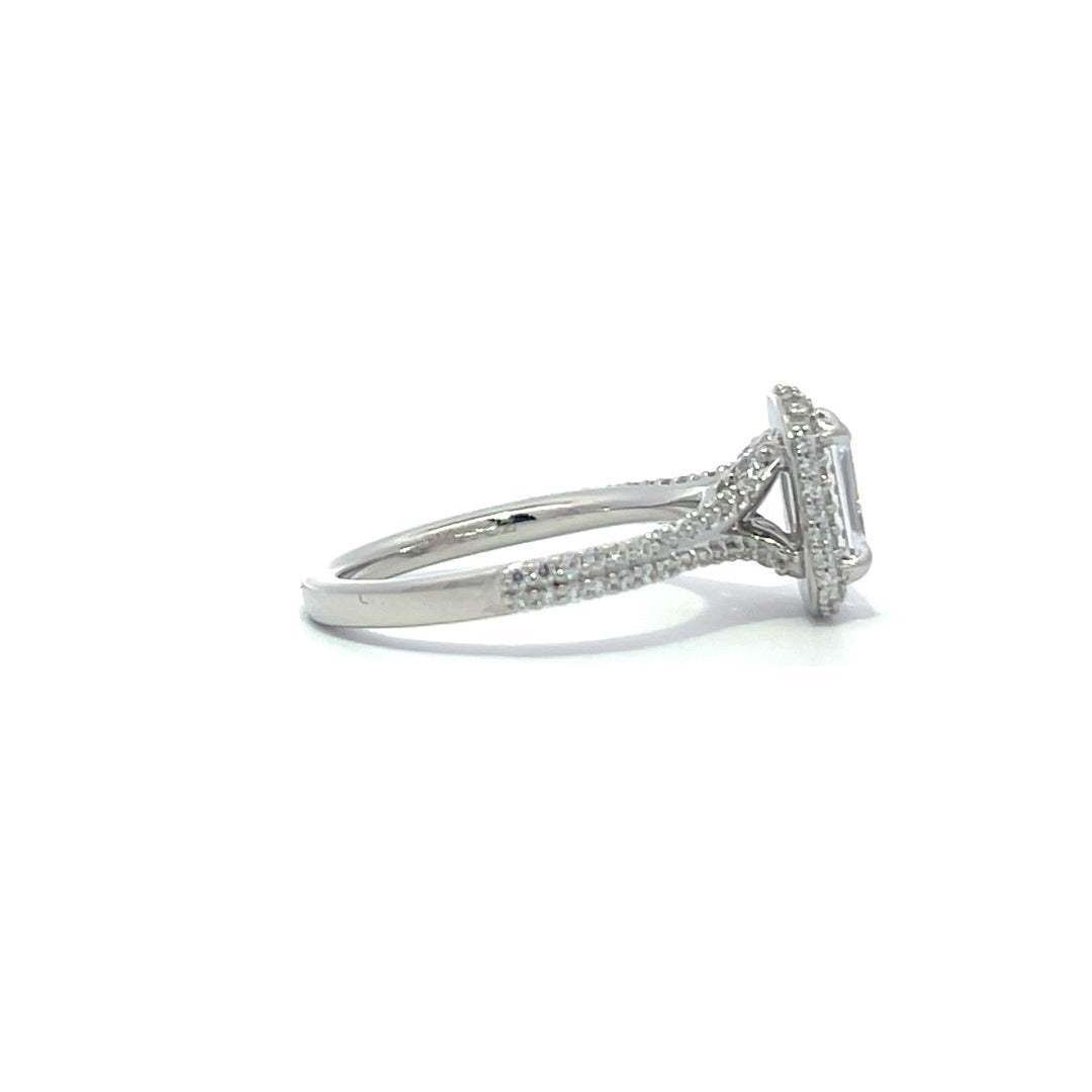 Silver emerald-cut engagement ring with a double halo setting on a white background