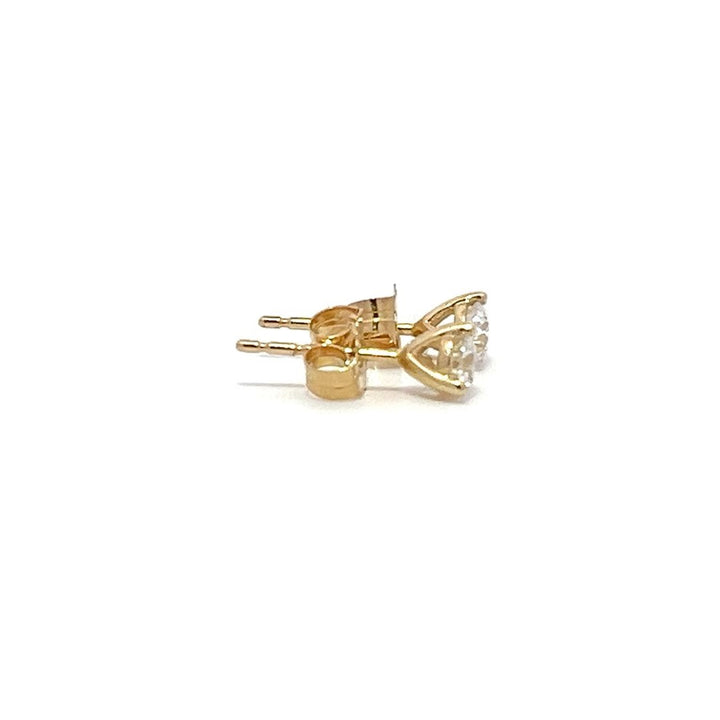 Pair of yellow gold stud earrings with a triangular setting of diamonds on a white background.