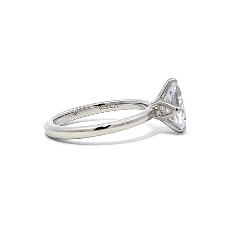 White gold oval diamond solitaire engagement ring on a white background.