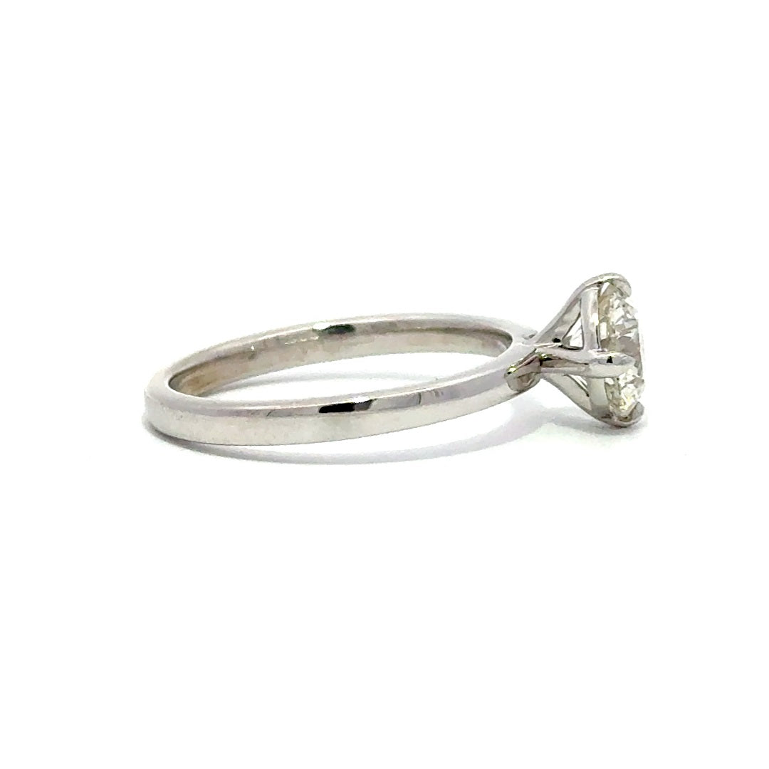 Silver gold solitaire engagement ring with a round cut diamond center stone on a white background.