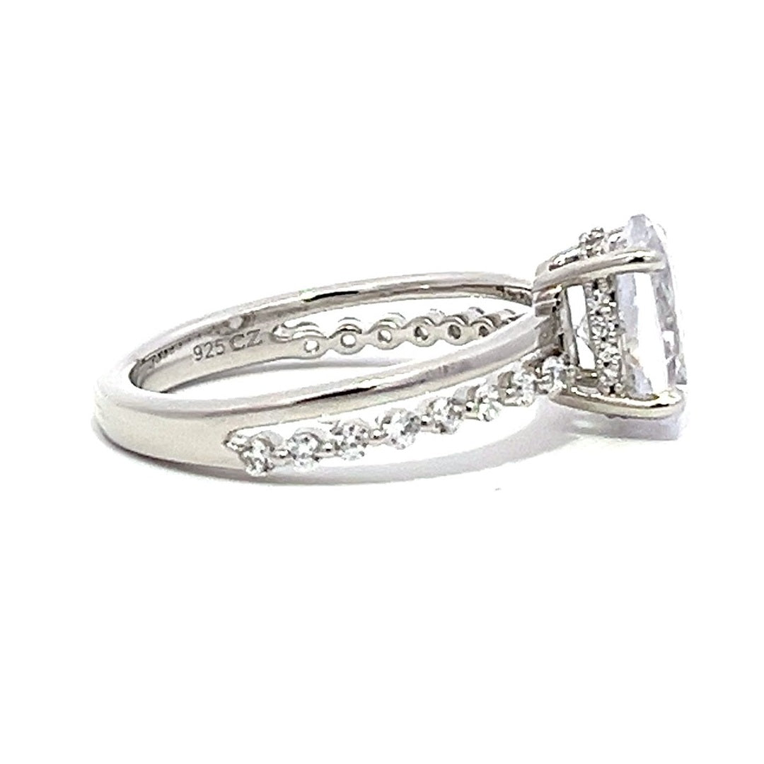 White gold round-shaped diamond engagement ring with a diamond band on a white background.