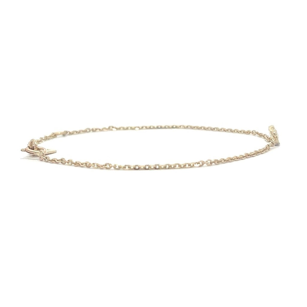 Yellow gold bracelet with a single diamond pendant in a bezel set on a white background.