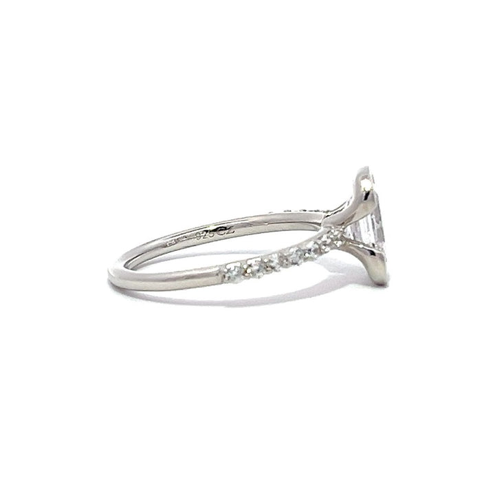 White gold pear-shaped diamond engagement ring with a diamond band on a white background.