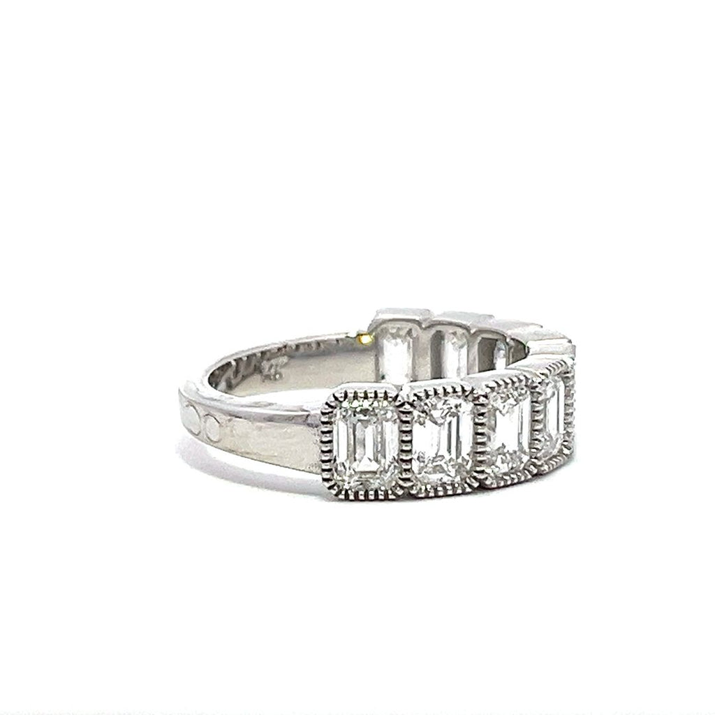 White gold eternity band with bezel-set emerald diamonds on a white background.