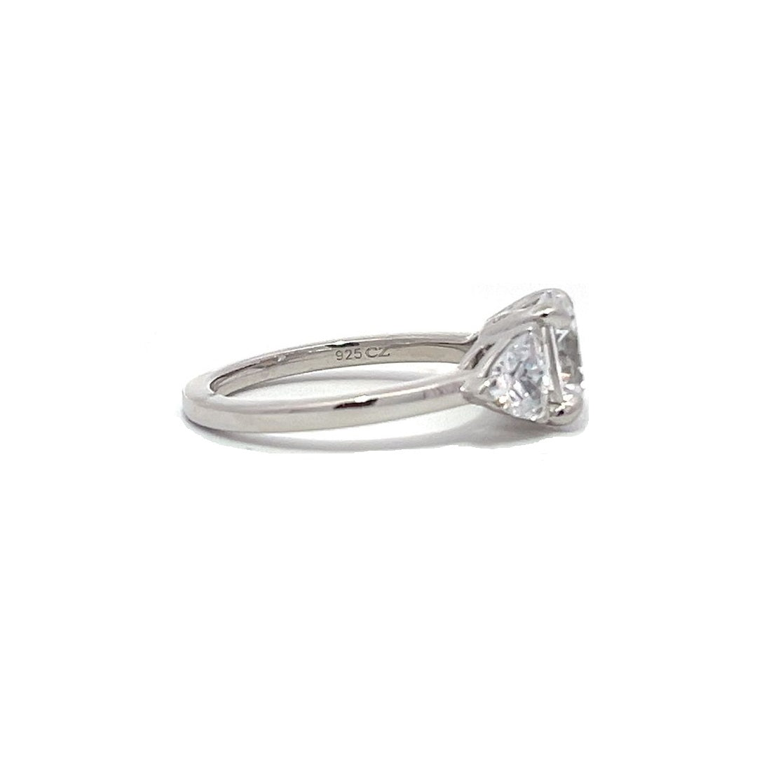 White gold three-stone diamond engagement ring with pear-shaped side stones on a white background