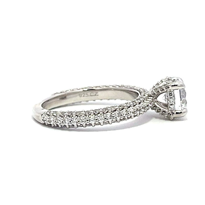 White gold round-shaped diamond engagement ring with a diamond band on a white background.