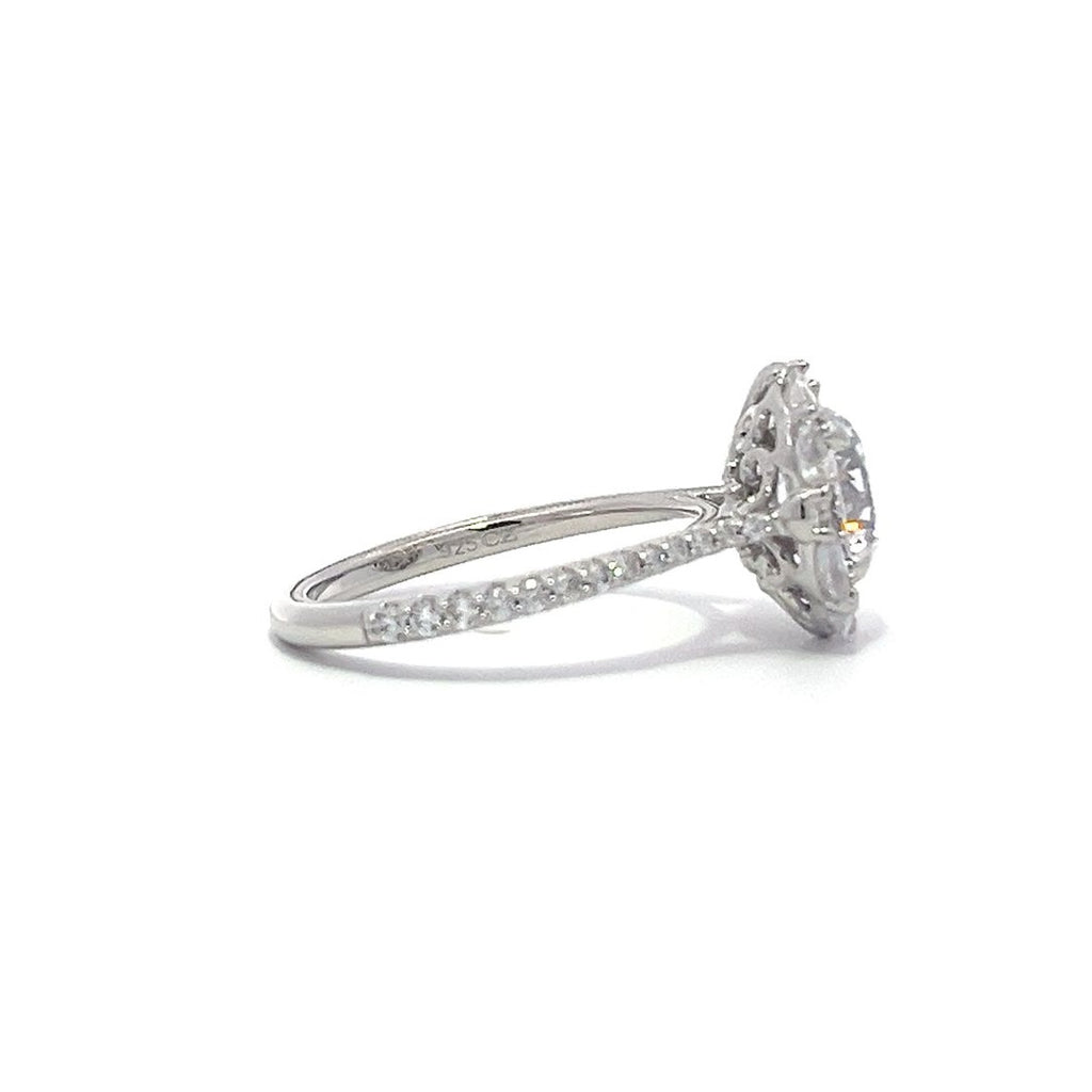 Silver engagement ring with a diamond halo setting and a diamond band on a white background