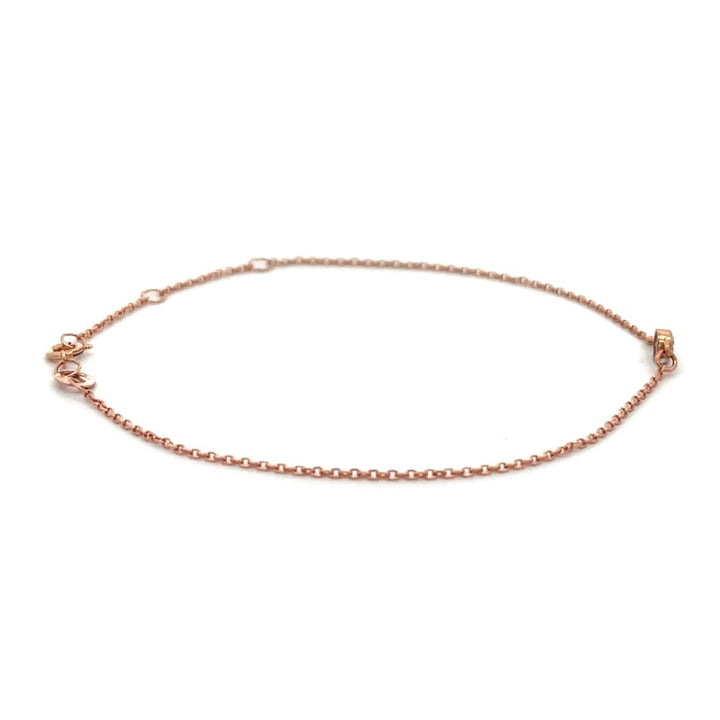 Rose gold bracelet with a single diamond on a white background.