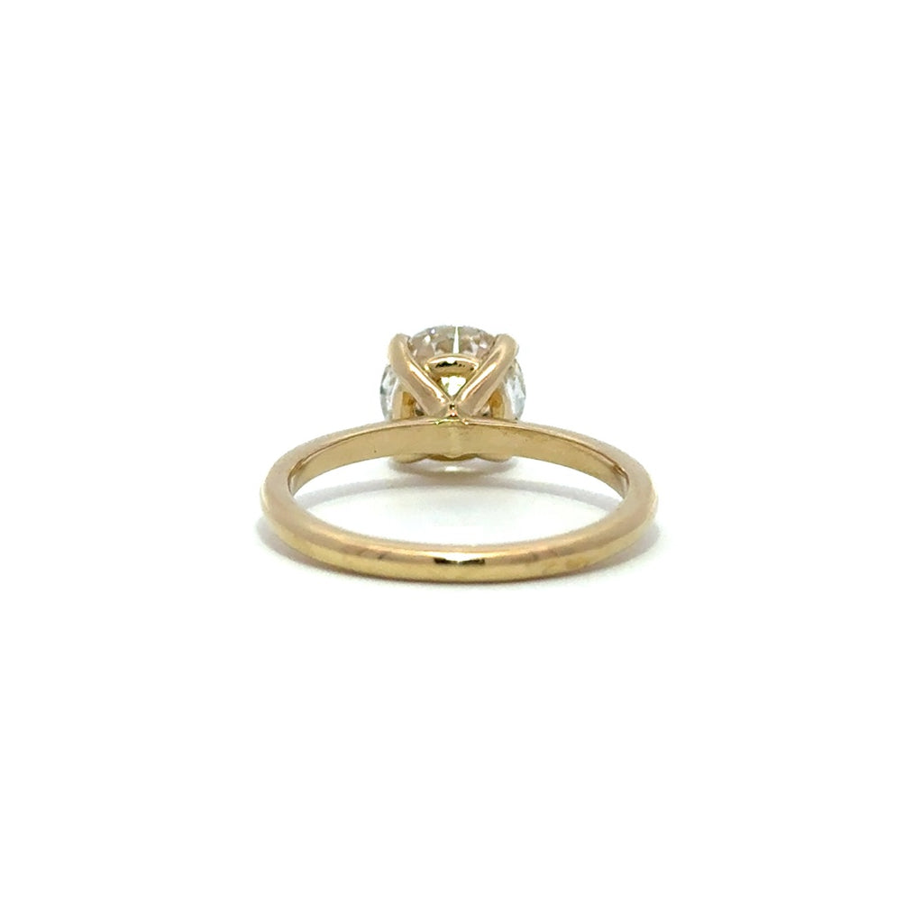 Yellow gold solitaire engagement ring with a round-cut diamond center stone on a white background.