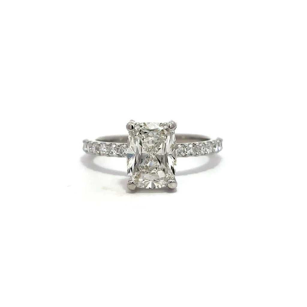 White gold engagement ring with diamond center stone and a diamond-studded band, on a white background.