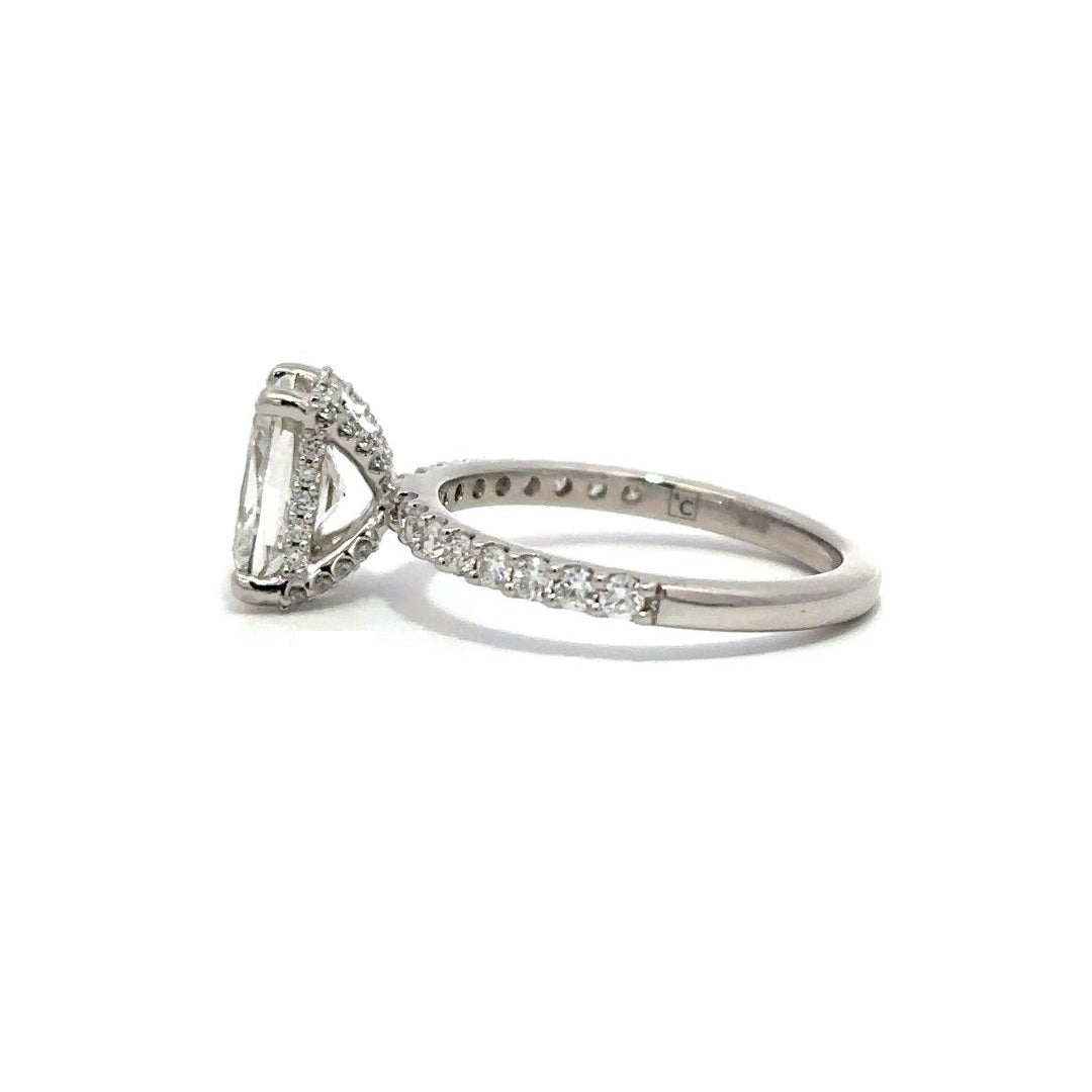 White gold engagement ring with diamond center stone and a diamond-studded band, on a white background.