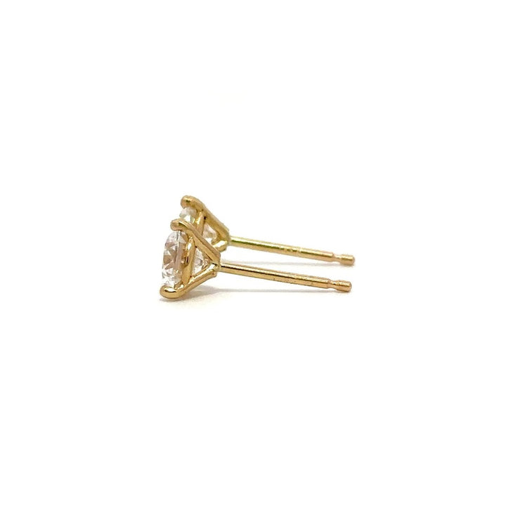 Pair of yellow gold stud earrings with a prong setting of diamonds on a white background.