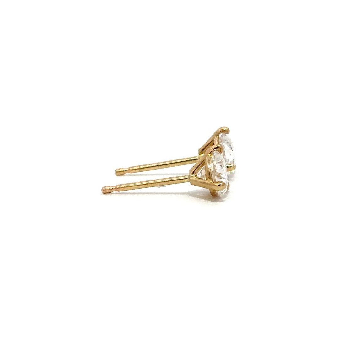 Pair of yellow gold stud earrings with a prong setting of diamonds on a white background.