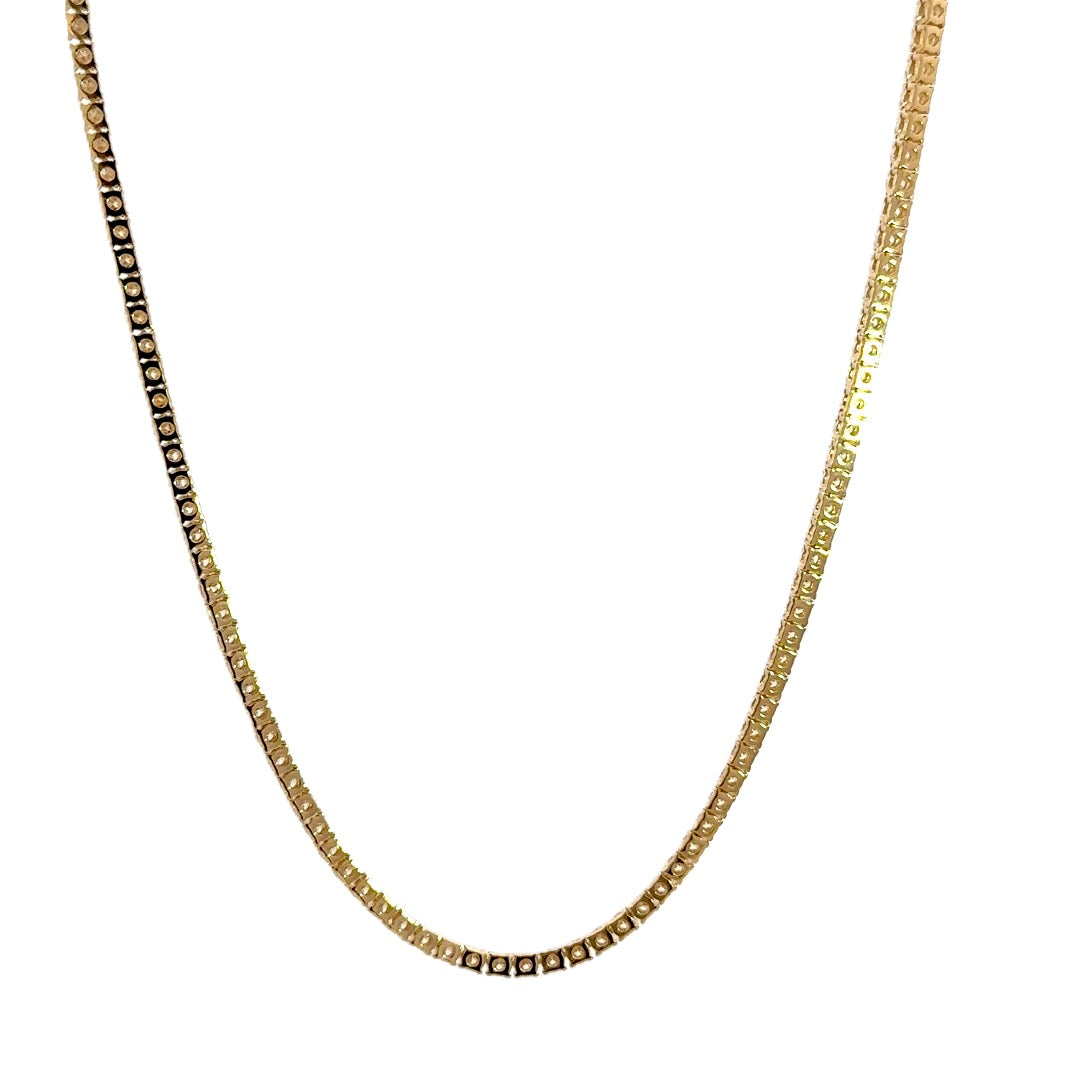 Gold tennis necklace on a white background.