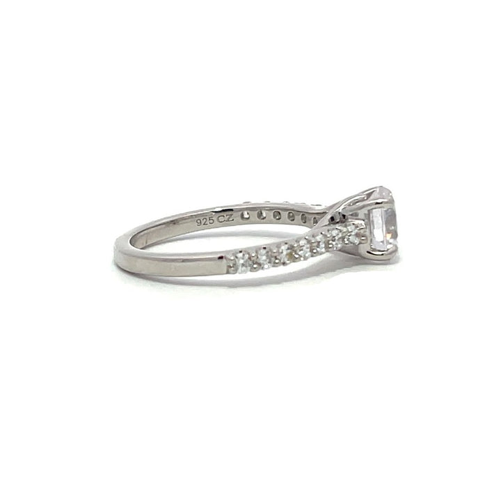 White gold round-shaped diamond engagement ring with a diamond band on a white background.