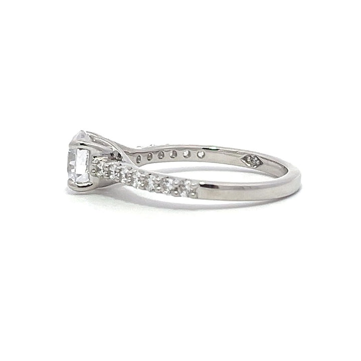 White gold round-shaped diamond engagement ring with a diamond band on a white background.