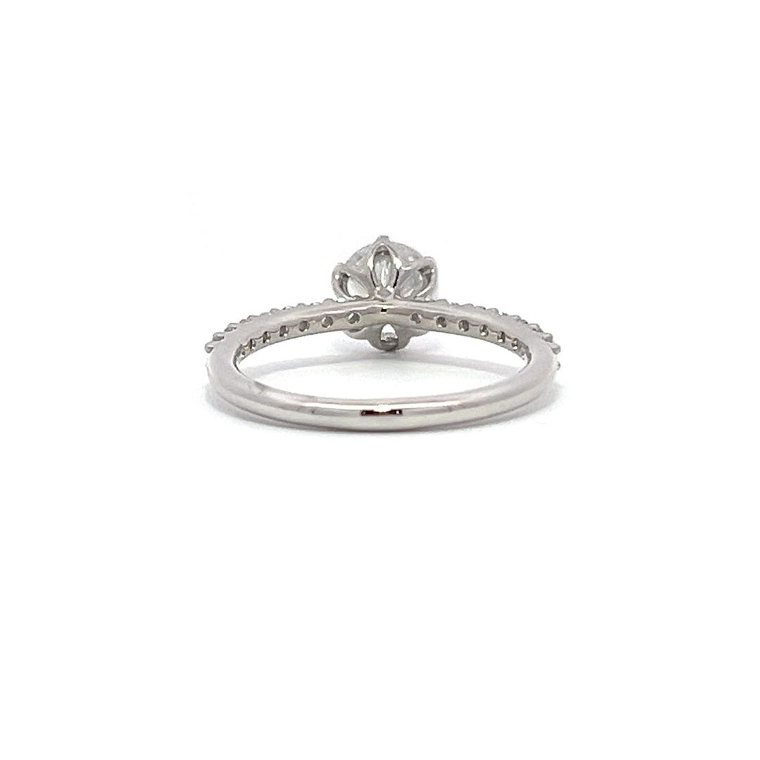 White gold round-shaped diamond engagement ring with a diamond band on a white background.