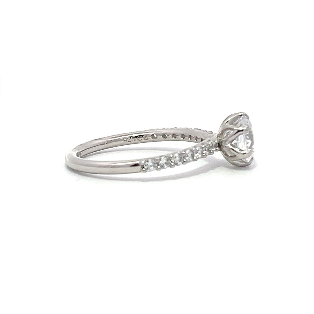 White gold round-shaped diamond engagement ring with a diamond band on a white background.