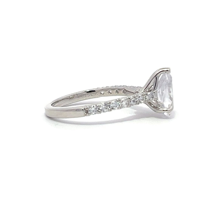 White gold pear-shaped diamond engagement ring with a diamond band on a white background.