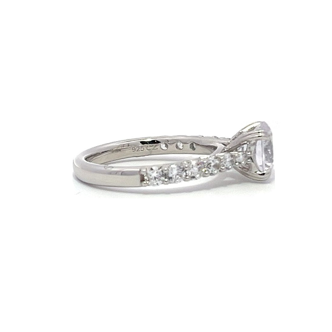 White gold round-shaped diamond engagement ring with a diamond band on a white background.