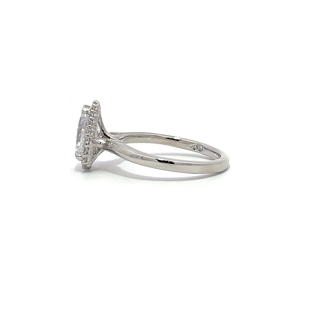 White gold pear-shaped diamond engagement ring with a halo setting on a white background