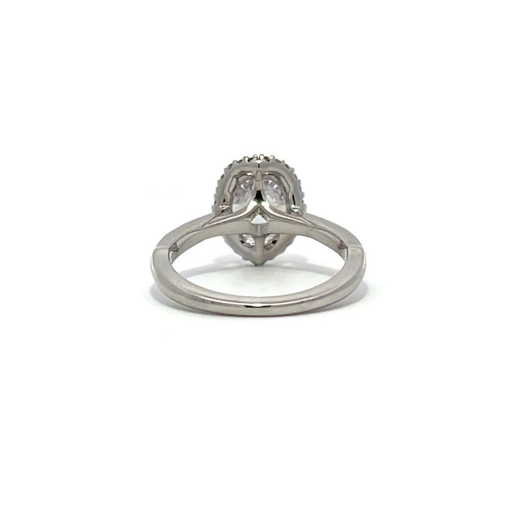 White gold oval diamond engagement ring with a halo setting on a white background