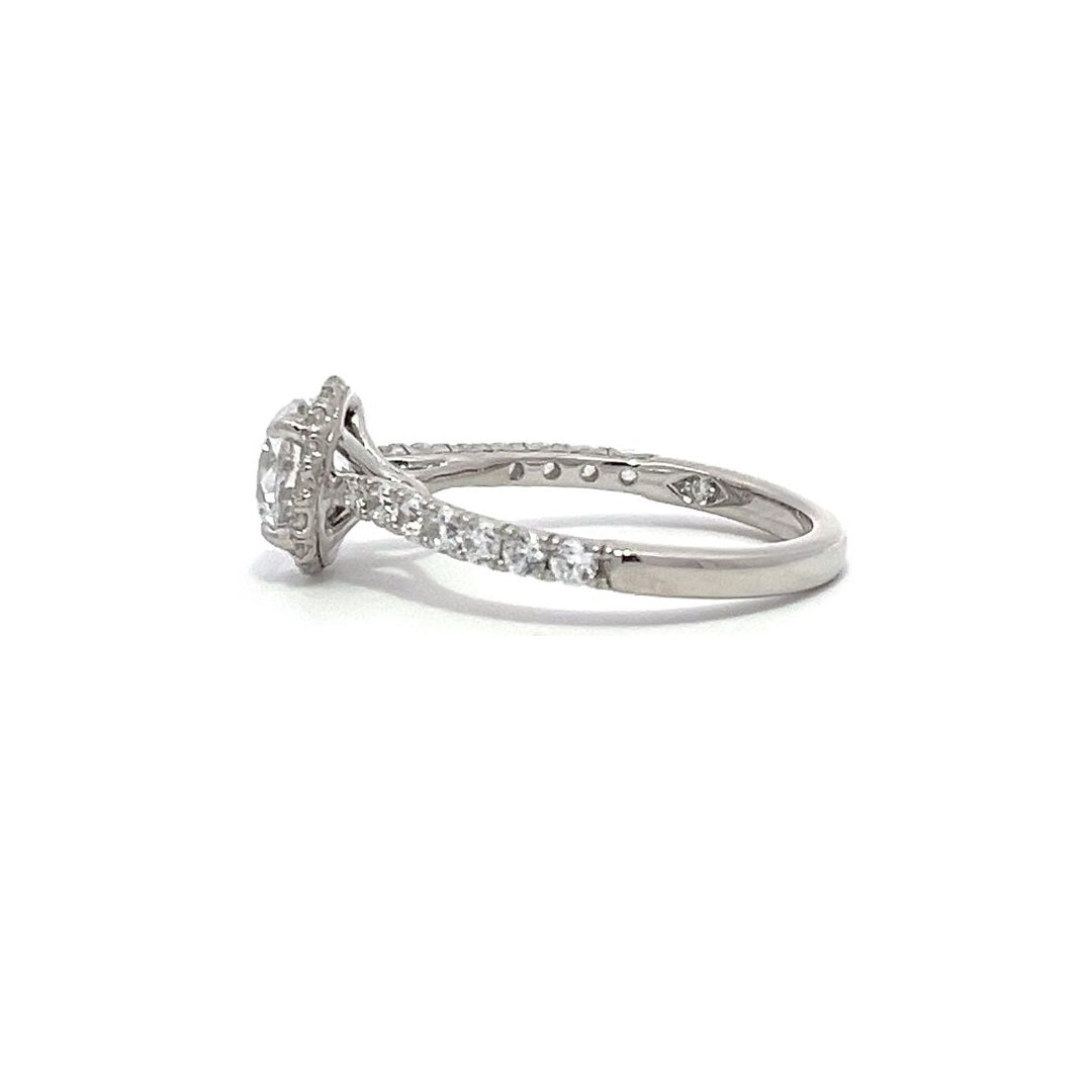 Silver engagement ring with a diamond halo setting and a diamond band on a white background