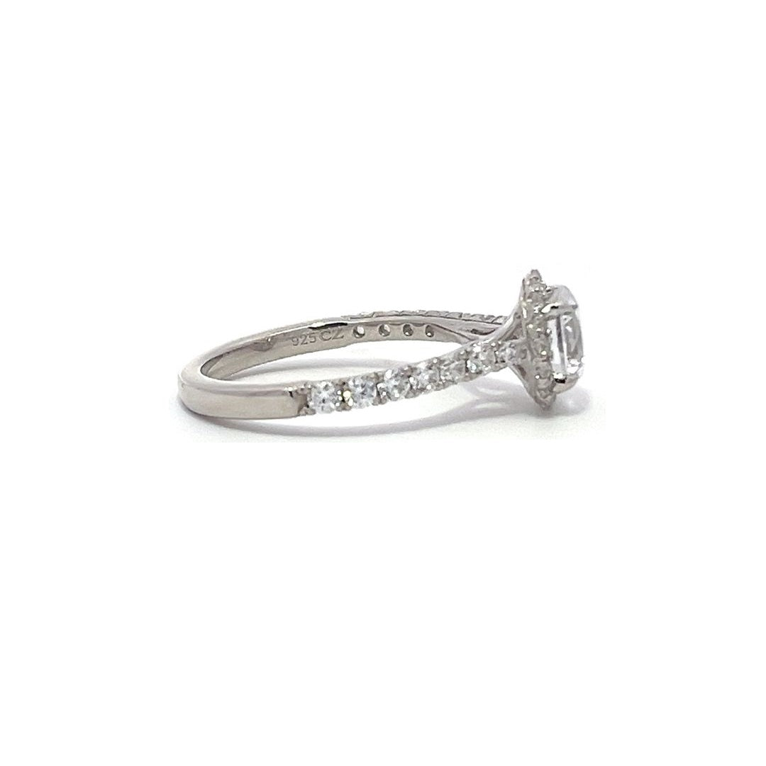 Silver engagement ring with a diamond halo setting and a diamond band on a white background